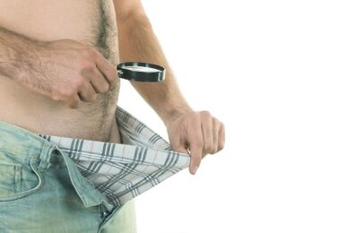 Ein Mann schaut auf seinen Penis und möchte ihn vergrößern